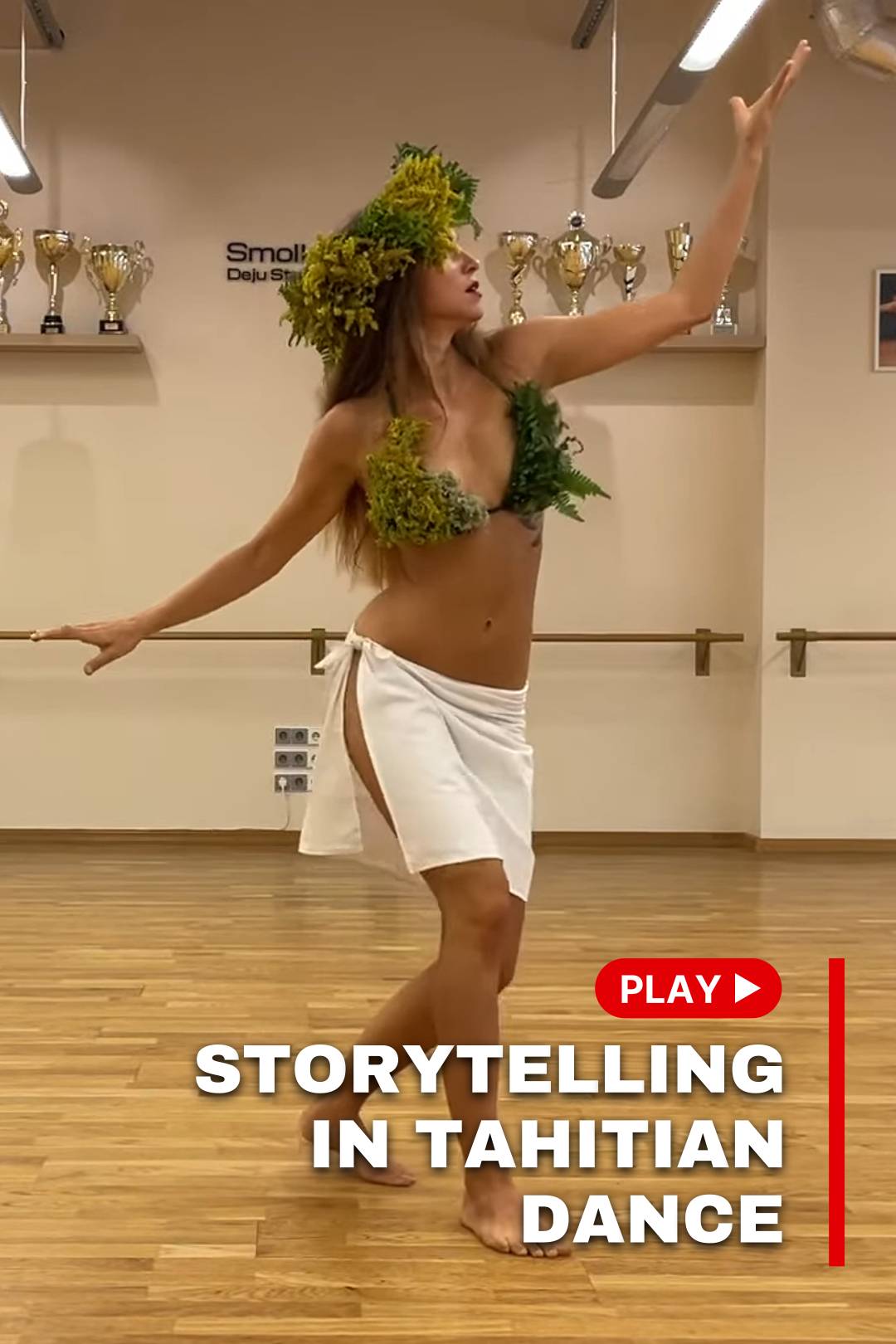 A woman in a white skirt dances tahitian dance in a dance studio
