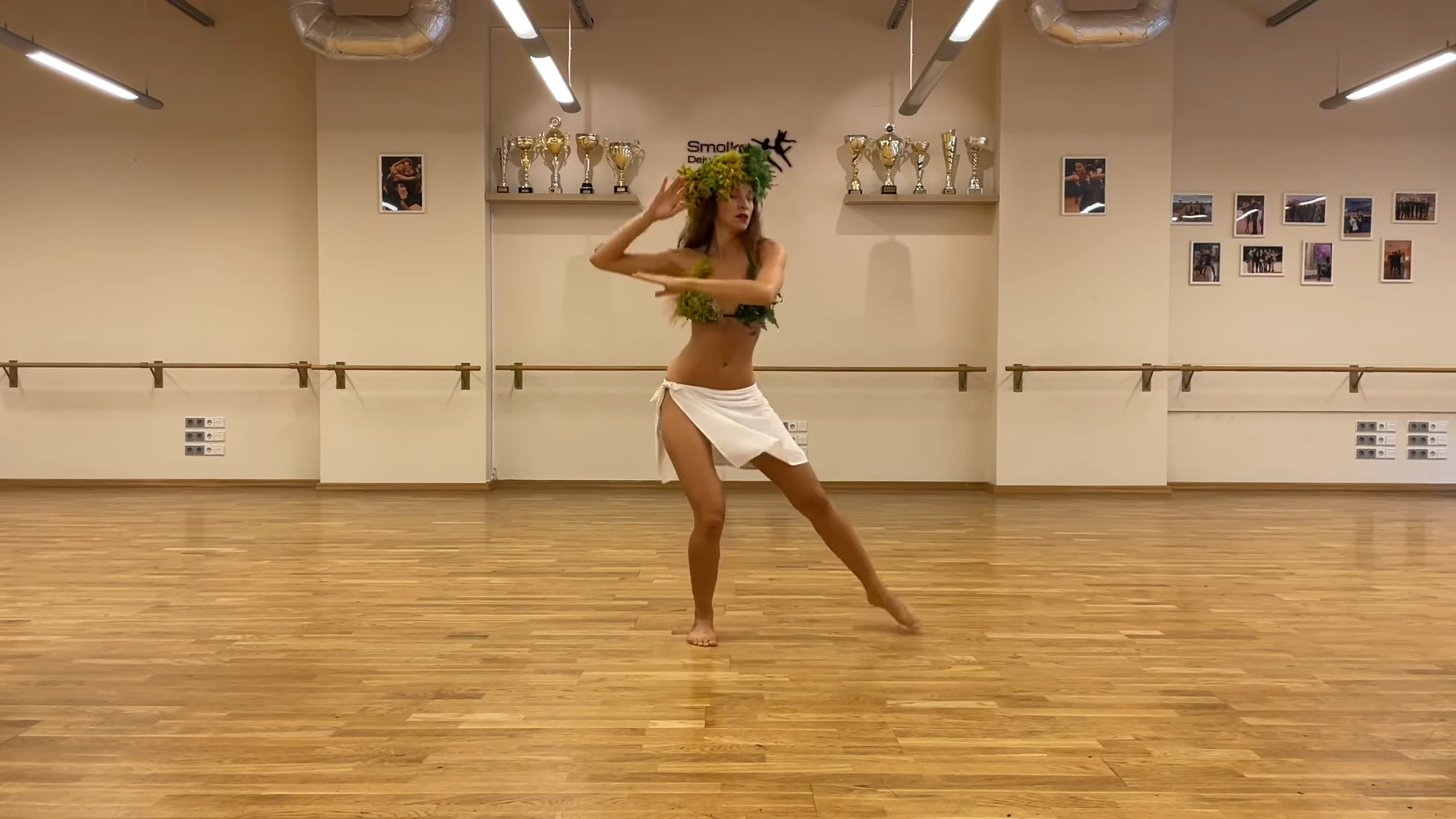 Woman in a white skirt dances tahitian dance in a dance studio